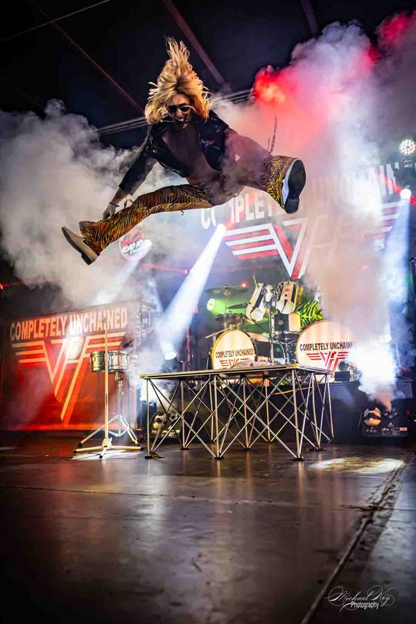 Geno mid-air through smoke and stage light.