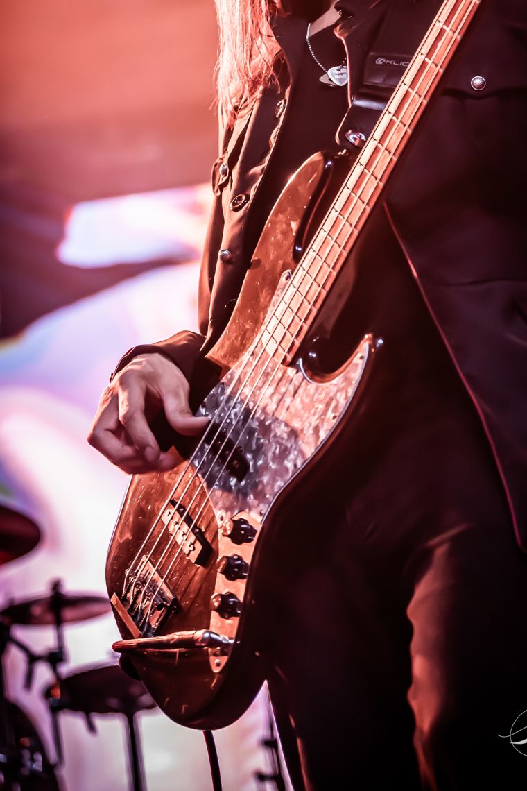 Detail: a hand on the strings of a sparkle bass. Photo: Michael Key Photography.