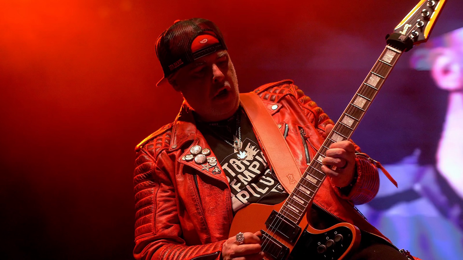 EPK 2026 cover frame: the guitarist in a red leather jacket and STP shirt under red stage light